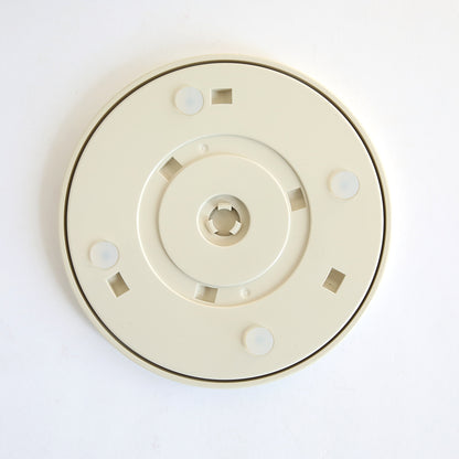 A beige, round plastic accessory disk with a central hole, square cutouts, and grips for the Empress Elite Mini Machine with 13" Plates. Shown on a white background.