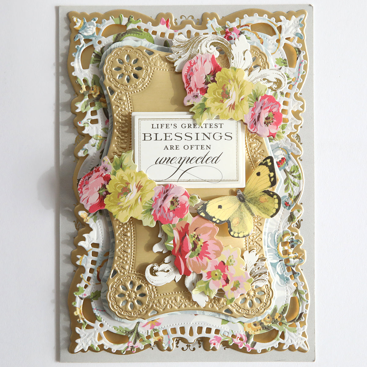 An ornate card showcases floral patterns and a butterfly, adorned with the phrase "Life's greatest blessings are often unexpected" at its heart. Its uplifting message gleams like the Beautiful Blessings Sentiment Stickers, adding elegance and charm.