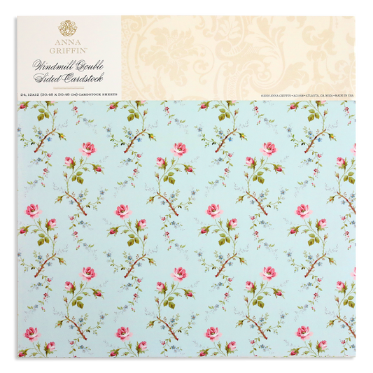 A light blue cardstock cover showcases a pattern of pink roses and green stems, with "Anna Griffin, Windmill 12x12 Cardstock" on top. Ideal for elegant designs using the Windmill Easel Dies.