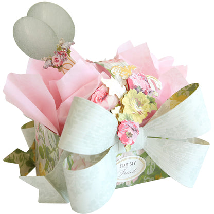 The Bow Box Dies create a floral treat box with a large white bow, pink tissue paper, flower accents, two mesh balloons, and a "For My Friend" tag—perfect for making memorable gift boxes.