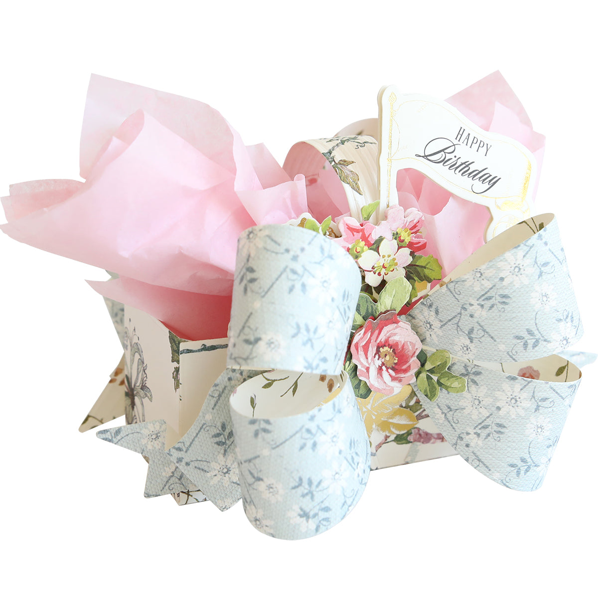 A festive birthday treat box made with Bow Box Dies, decorated with a big blue floral bow, pink tissue paper, and a floral "Happy Birthday" tag.