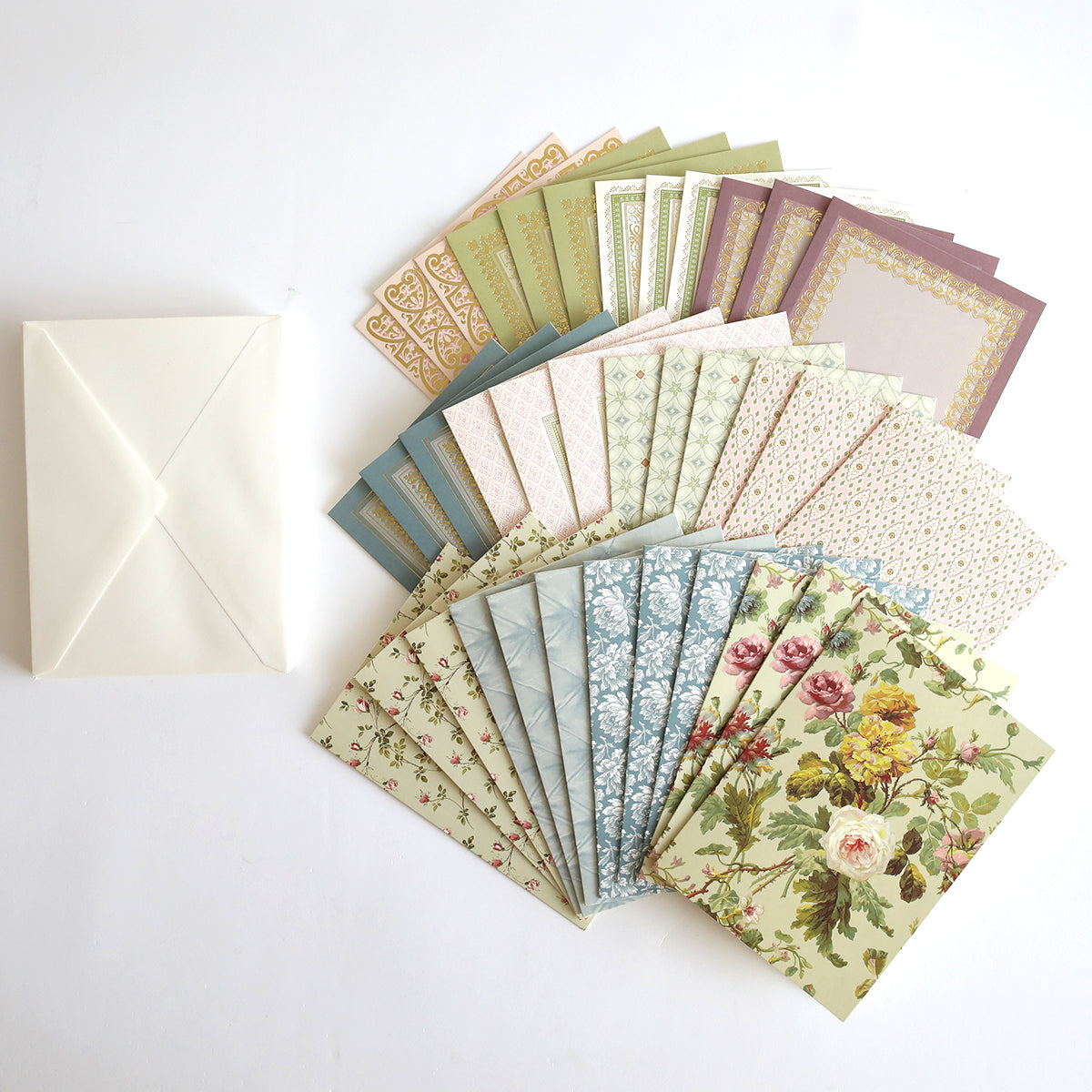 A set of Francesca Cards and Envelopes, showcasing handmade card designs with beautiful patterns and florals, is displayed fanned out beside a single plain white envelope on a white background.