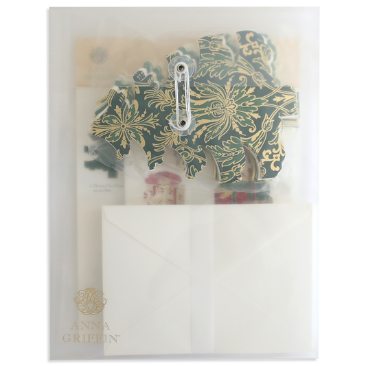 A transparent folder labeled "Tree Shaped Cards and Embellishments" contains decorative floral cutouts, Christmas tree embellishments, and a partially visible white envelope.