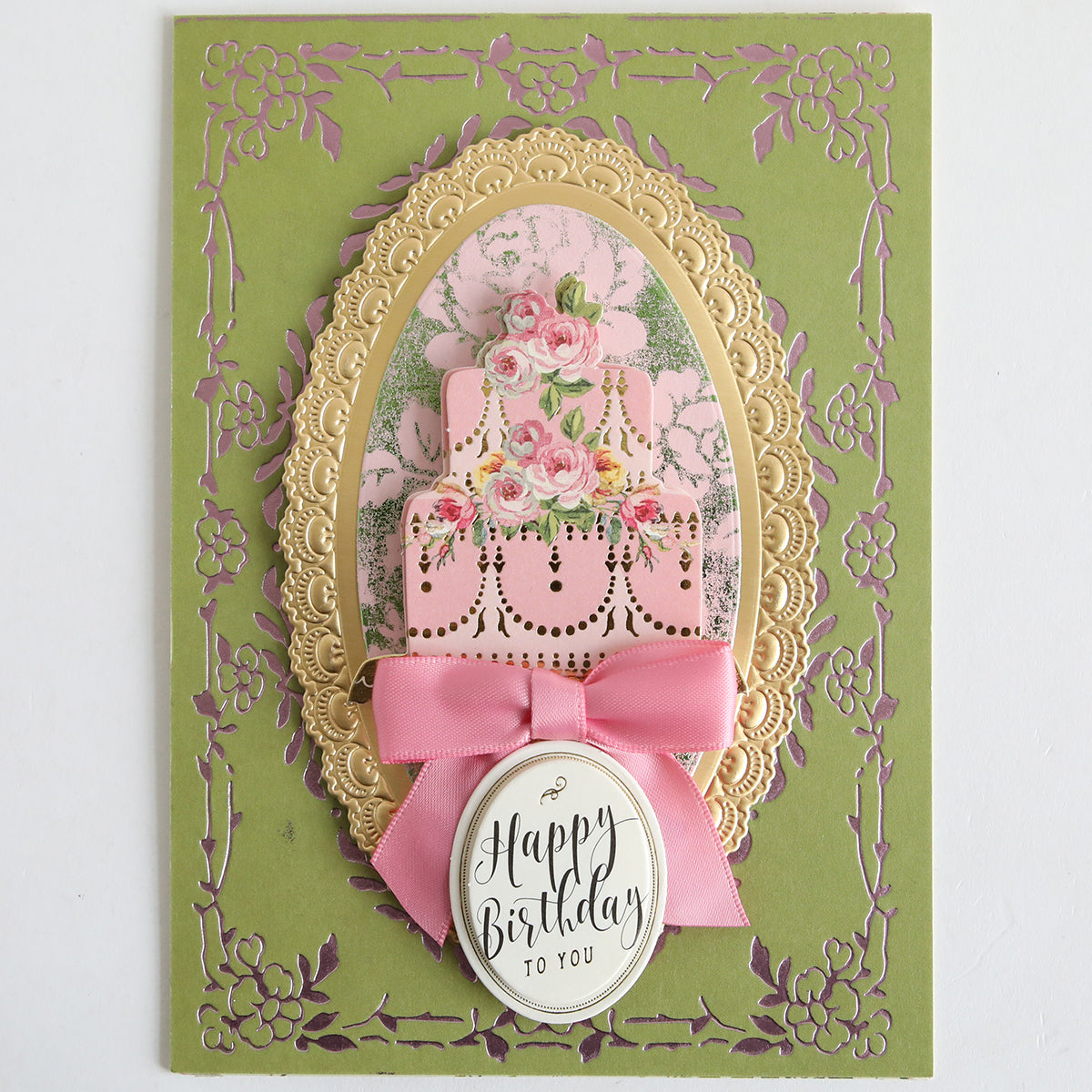 A decorative birthday card featuring a pink cake, florals, gold frame, bow, and an oval "Happy Birthday to You" label—crafted with Color Drenched Cardstock Sage Green—perfect for handmade card making enthusiasts.