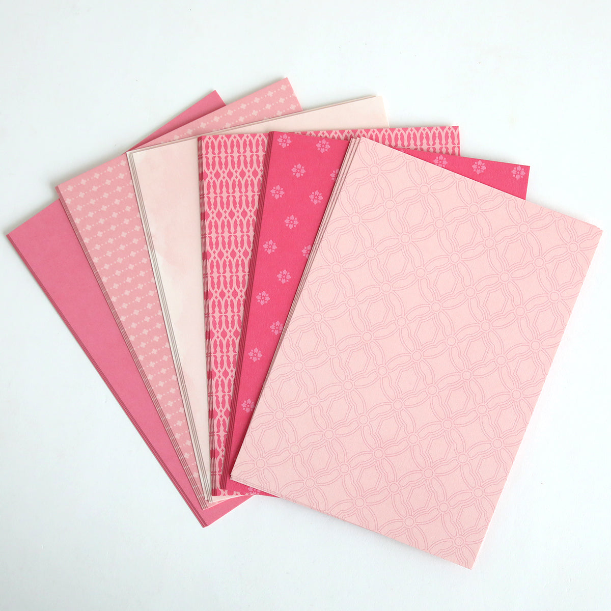 The "Color Drenched Cardstock Peony Pink" set features six pink patterned notebooks, ideal for card making, displayed fanned out on a white background.