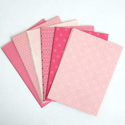 The "Color Drenched Cardstock Peony Pink" set features six pink patterned notebooks, ideal for card making, displayed fanned out on a white background.