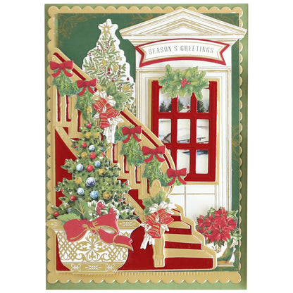 A festive Christmas card featuring Grand Staircase Dies and Embellishments, highlighted by a gleaming staircase adorned with shimmering garland accents, elegant bows, a vibrant Christmas tree, and a welcoming door with a "Season's Greetings" sign. Poinsettia plants and lush holiday greenery provide warmth while the detailed 3-dimensional cutting dies from the Grand Staircase Dies and Embellishments set bring this enchanting holiday scene to life.