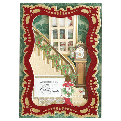 Christmas card featuring a beautifully detailed staircase made with the Grand Staircase Dies and Embellishments, decorated with garland, a grandfather clock beside it, a festive red border, and the message, "Wishing you a Merry Christmas.