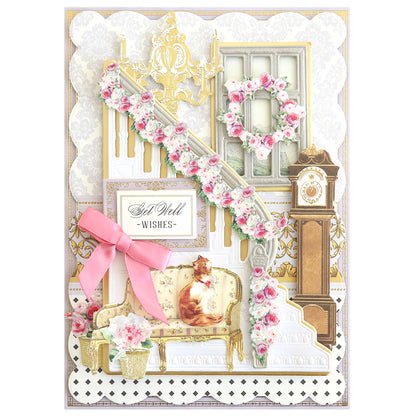 A decorative greeting card made with Grand Staircase Dies, featuring a floral staircase, chandelier, grandfather clock, cat on a sofa, pink bow, and a heartfelt "Get Well Wishes" message. Great for card making and scrapbook pages.