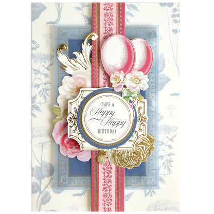 The Birthday Present Card Making Kit includes decorative supplies to create a handmade birthday card with flowers, balloons, and gold accents featuring "Have a Happy Happy Birthday"—ideal for fans of unique card making.
