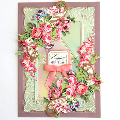 Greeting card crafted from Luxury Iridescent Foil Cardstock, embellished with embossed pink and red floral designs, gold accents, a pink ribbon, and “Happy Birthday” message centered on the front.