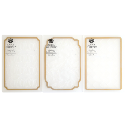 Three Spellbound Patterns Cut & Emboss Folders are displayed side by side in clear plastic packaging with gold trim—ideal for adding flair to your seasonal crafting projects.