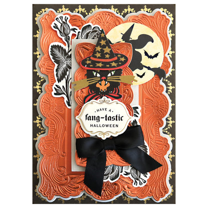 Halloween card with a Gothic Revival 3D Frames embossed orange border, black cat in witch hat, moon with bats, and label "Have a fang-tastic Halloween," finished with a black ribbon bow for added dimension.
