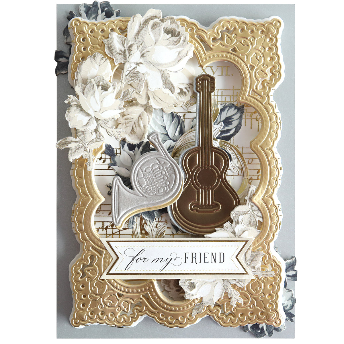 A decorative card made with Music 3D Scene Dies, featuring gold borders, white flowers, a French horn, guitar, musical accents, and finished with a "for my FRIEND" banner.