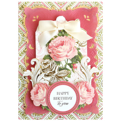 Add vintage flair to your crafts with Antique Greetings Postcard Embellishment Stickers—beautiful pink roses, gold accents, and "Happy Birthday to you" on a patterned background, perfect for scrapbooks or fans of unique designs.