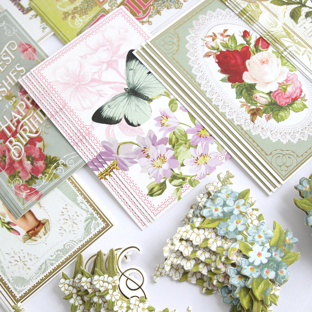 Antique Birthday Postcard Embellishment Stickers featuring floral and butterfly designs, ideal for scrapbooking or vintage crafts, are displayed on a white surface.