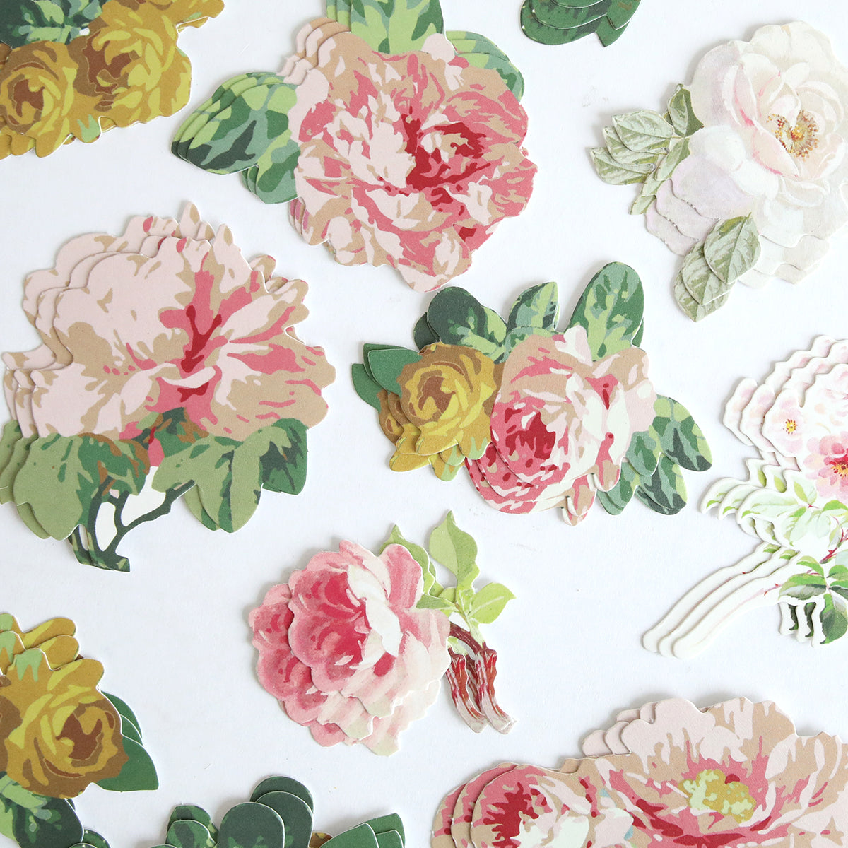 Virginia Die Cut Embellishments are colorful paper cutouts of flowers and green leaves, ideal as floral die cut stickers or scrapbook accents, beautifully displayed on a white background.