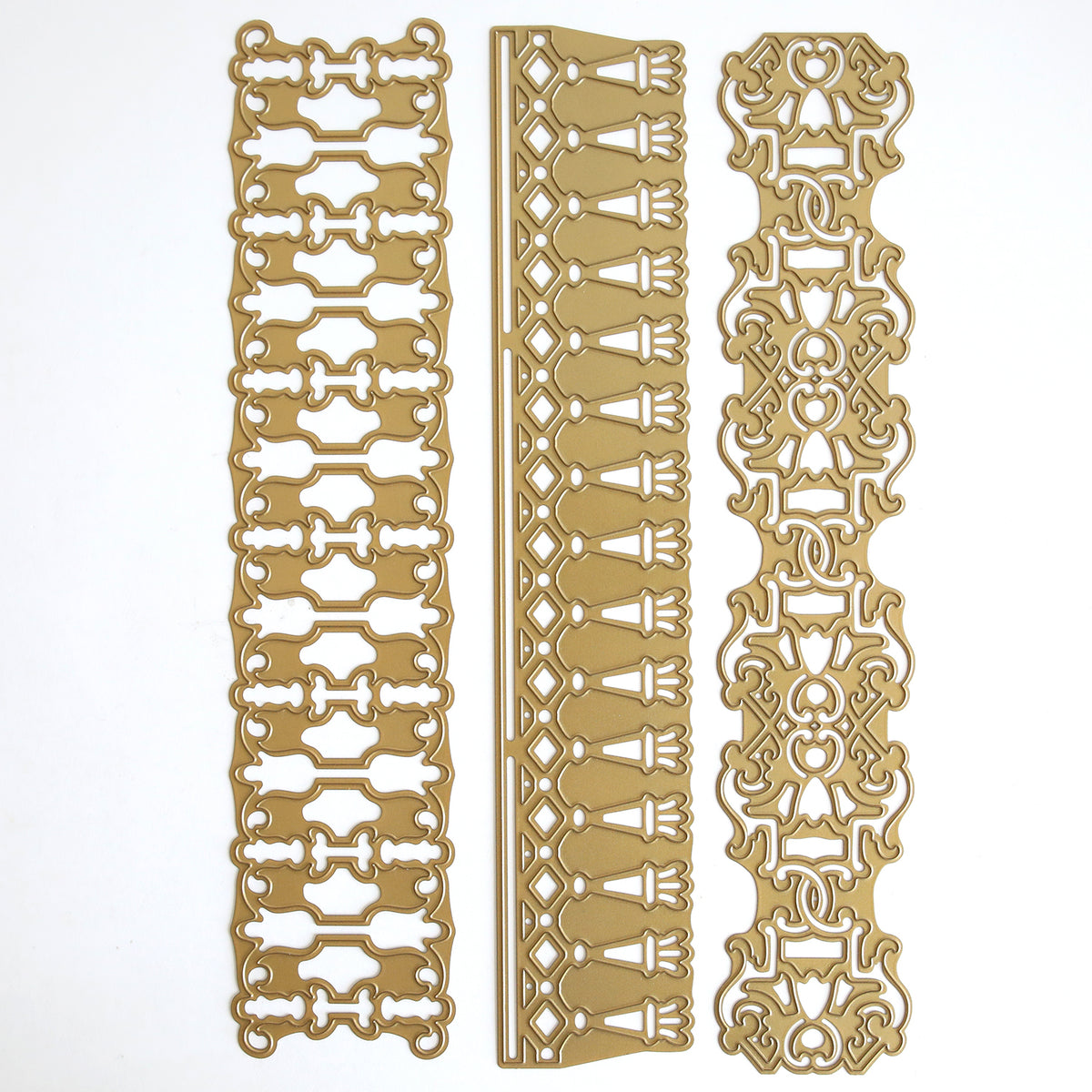 Three intricate 12″ Regal Trimmings Border Dies, crafted from rose gold matte foil cardstock and featuring unique decorative patterns, are arranged vertically side by side on a white background.