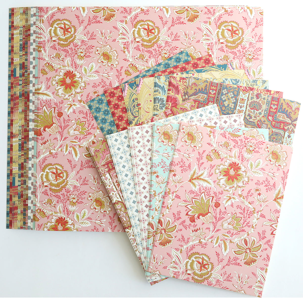 A set of patterned cardstock in pink, red, and gold is fanned out on a white background—ideal for the Jasmine Cardstock and Matte Foil Bundle or any creative paper crafting project.