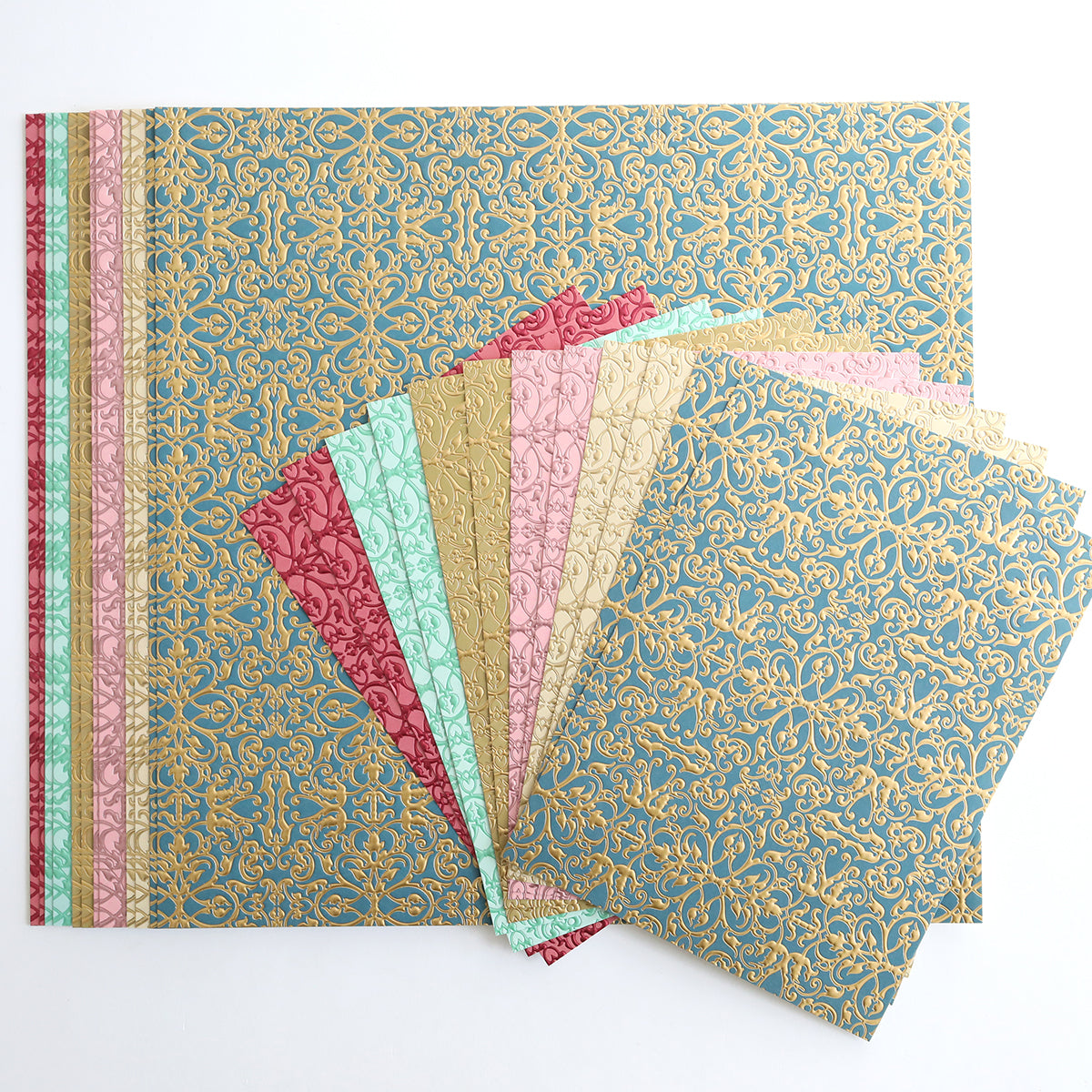Jasmine Luxury Tonal Foil Cardstock features decorative paper sheets in assorted colors with gold patterns, artfully arranged in a fan shape on a white background—ideal for crafting projects.