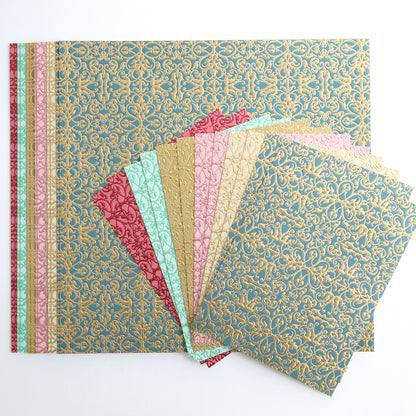 Jasmine Luxury Tonal Foil Cardstock features decorative paper sheets in assorted colors with gold patterns, artfully arranged in a fan shape on a white background—ideal for crafting projects.