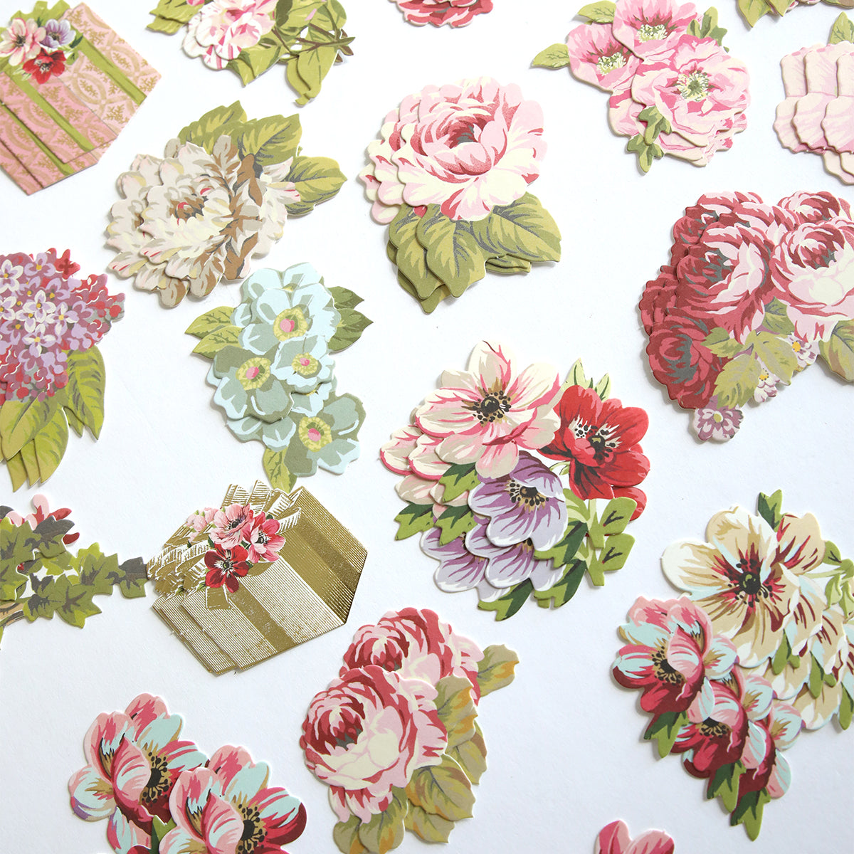 Create Everyday Embellishments: Assorted vintage-style paper cutouts, including colorful flowers and gift boxes with layered blooms and die-cut details, displayed on a white background.