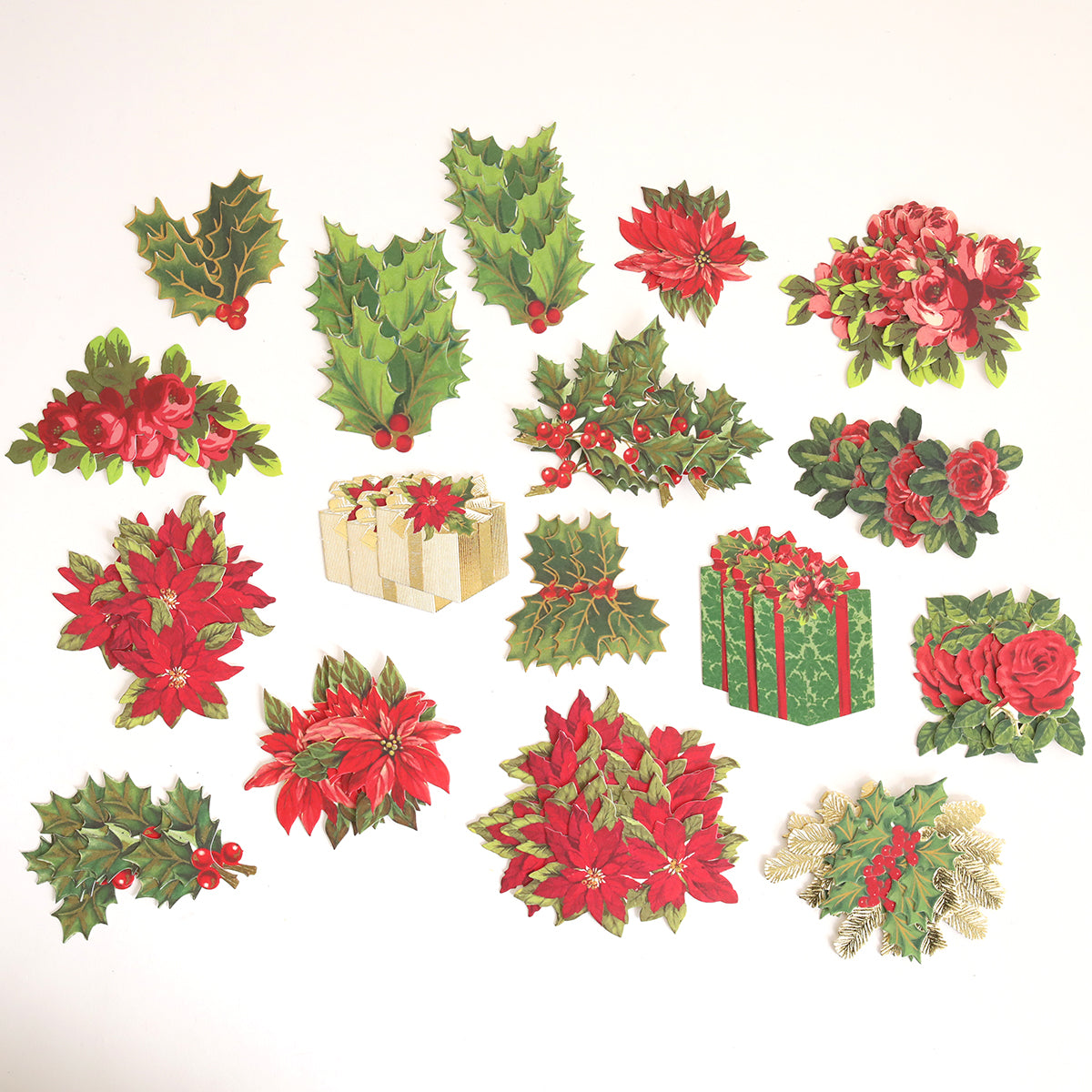 Create Holiday Embellishments features assorted layered die cuts with Christmas-themed designs like poinsettias, holly leaves with berries, roses, pine sprigs, and wrapped gifts on a white background.