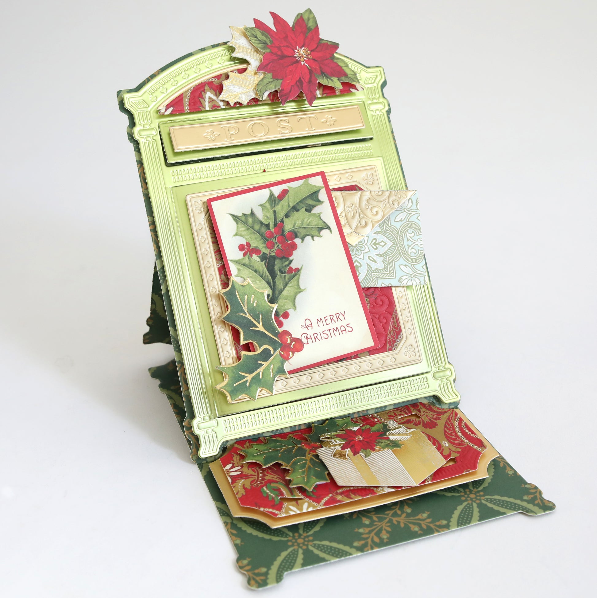 The Create Holiday Embellishments card features layered die cuts of holly and poinsettias, plus "A Merry Christmas" text in a vintage postbox design for a festive, three-dimensional holiday decoration.