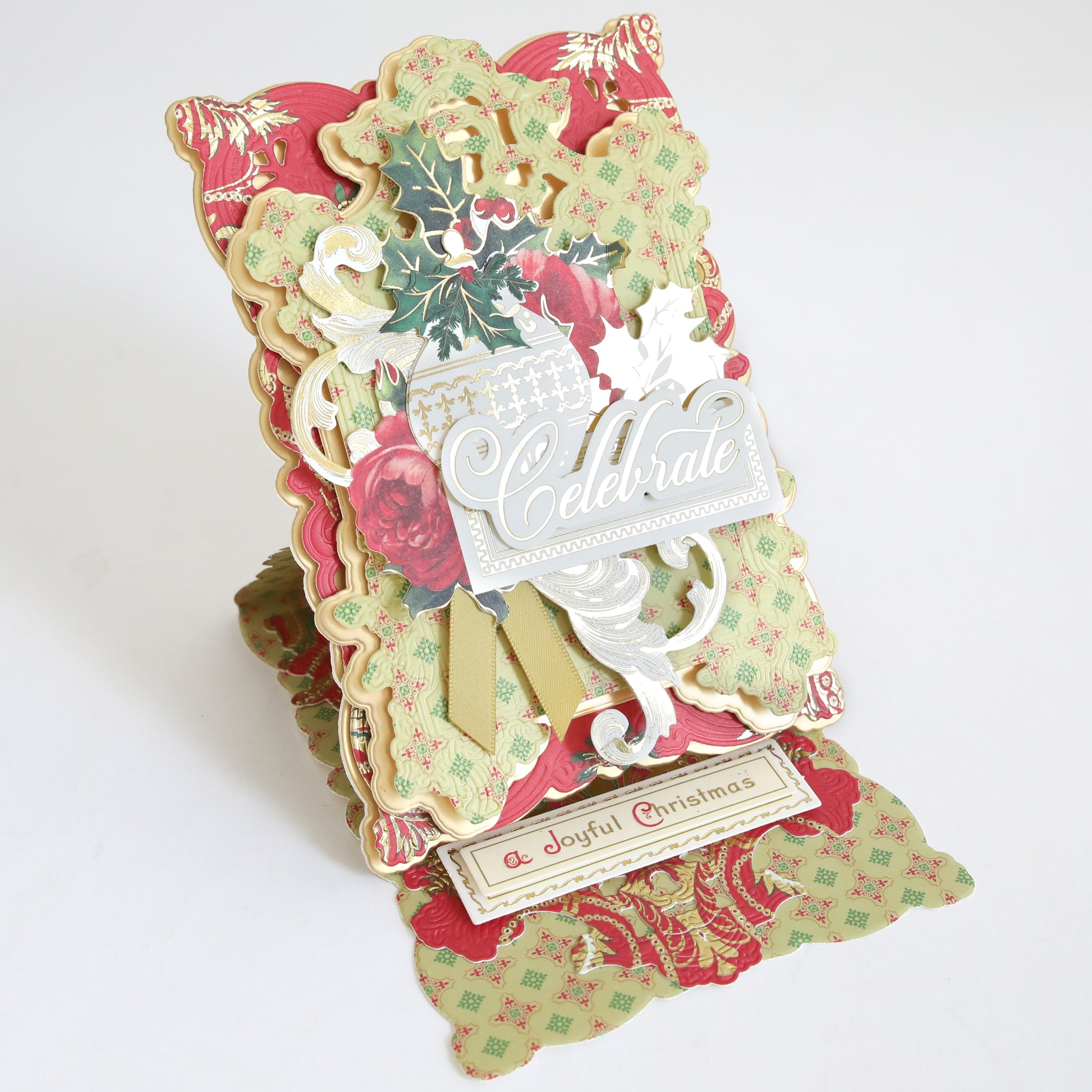 Create Holiday Embellishments pop-up card features layered floral patterns, festive accents, the word "Celebrate," and a bottom message: "A Joyful Christmas.