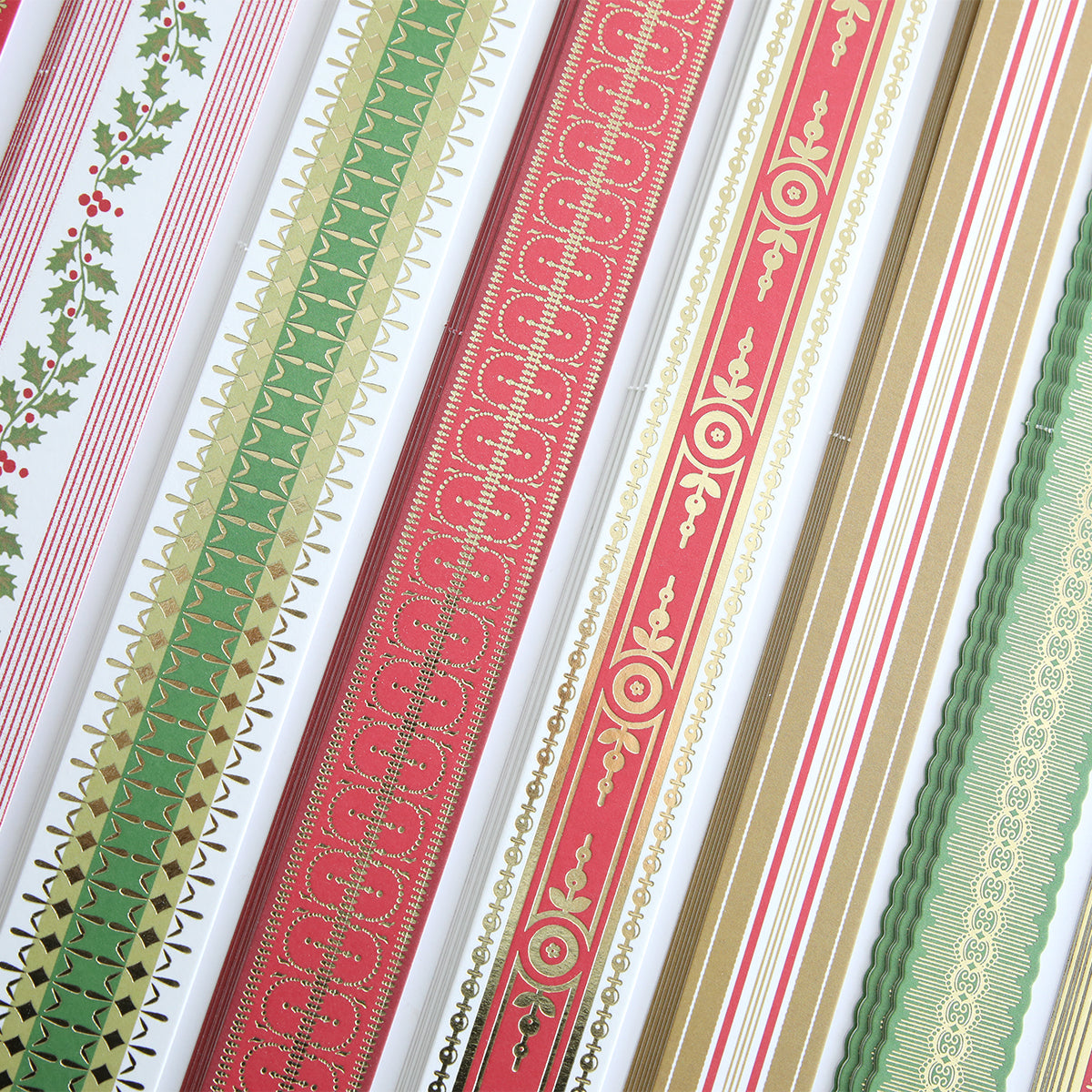 Rolls of decorative wrapping paper in red, green, gold, and white patterns—stripes, holly, ornate designs—arranged vertically; perfect to pair with Create Holiday Border Stickers for festive projects or gift wrapping.
