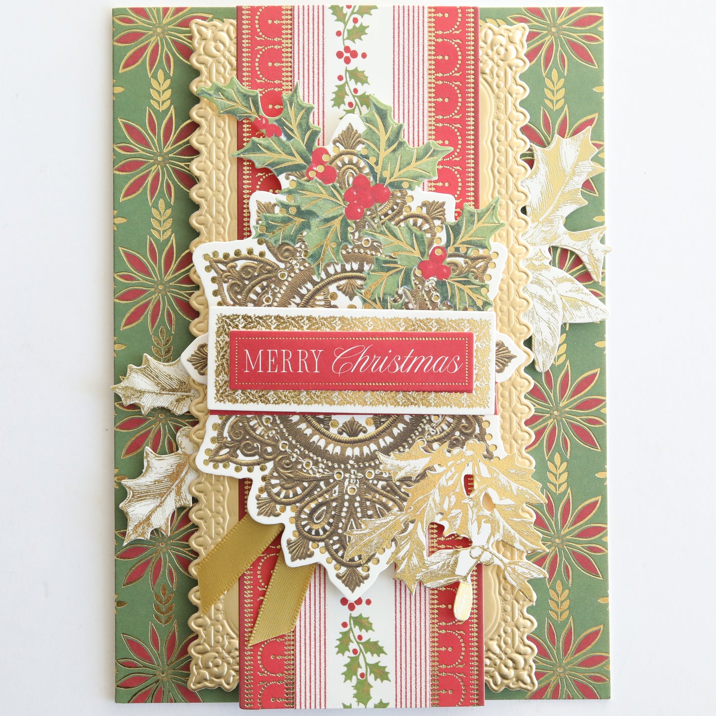 A decorative Christmas card with gold, red, and green patterns featuring holly and a "Merry Christmas" label—perfect for festive crafting or embellishing with Create Holiday Border Stickers.