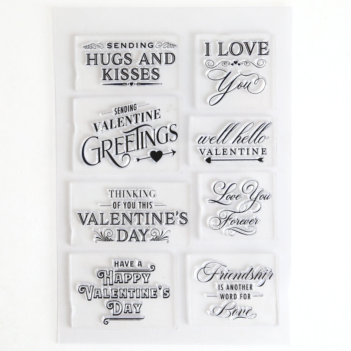 Lovely Sentiment Stamps: a sheet of clear stamps featuring "Hugs and Kisses," "I Love You," and "Valentine Greetings" in decorative fonts—ideal for adding sweet touches to handmade cards or scrapbook pages.