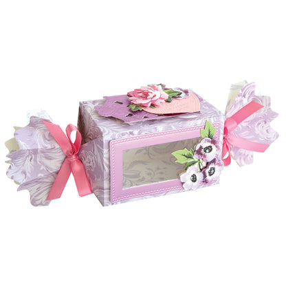 This decorative rectangular favor box features a clear window, pink floral patterns, pink ribbons, and paper flower embellishments—perfect for treats or pairing with Candy Wrapper Box Dies.