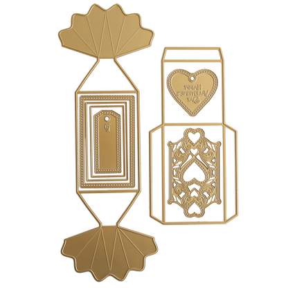 The Candy Wrapper Box Dies set includes two gold metal templates for crafting treat or favor boxes, featuring geometric designs, a heart with "Happy Valentine's Day," and detailed decorative accents.