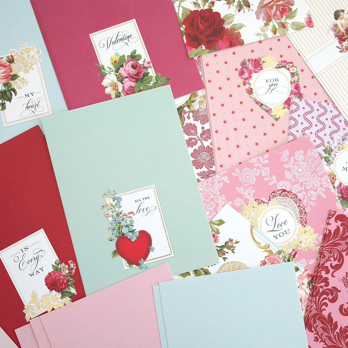 Valentine Clever Scene Cards are displayed on a flat surface, featuring pastel and floral heart-themed designs with interactive sliding card dies. Each set includes Valentine’s Day cards and envelopes perfect for creative greetings.