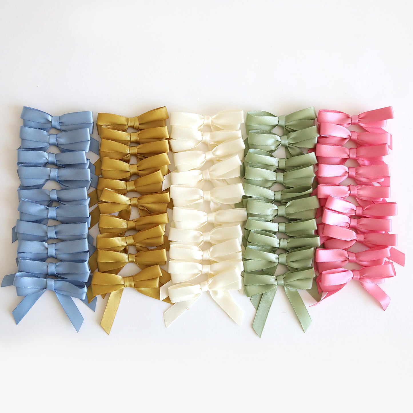 Perfect Double Bows 50 count—ten rows of satin bows in blue, gold, ivory, green, and pink on a white background. These pre-tied bows are ideal craft embellishments for all your projects.