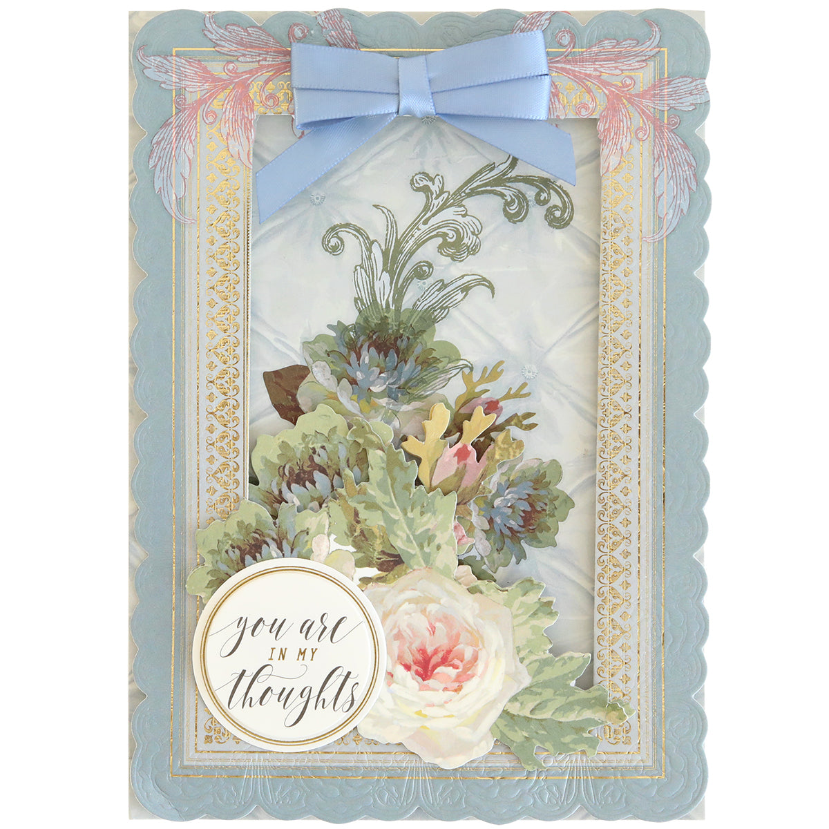 Crafted with the 3D Layer Dies with Pre-Tied Bows, this greeting card features a blue scalloped border, elegant floral design, satin and light blue ribbon bows, and a dimensional round label that reads “you are in my thoughts” in cursive—perfect for fans of handmade cards.