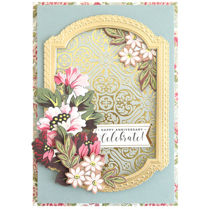 A decorative "Happy Anniversary" card with a gold ornate frame, pink and white flowers, and an elegant patterned background made using Gilded Damask Hot Foil Plates and embossing machines.