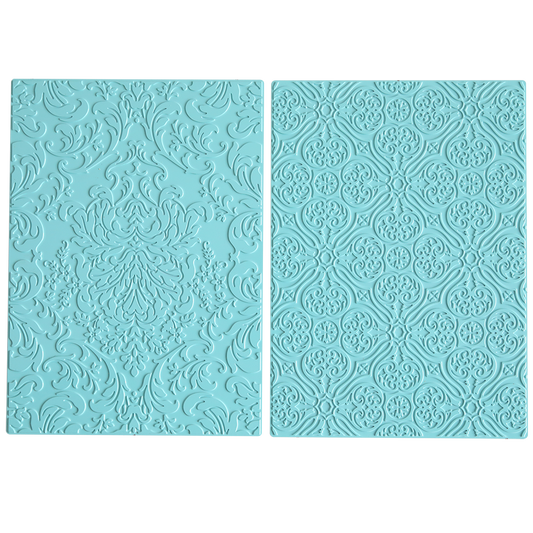 Two light blue silicone mats, inspired by damask designs, are placed side by side on a white background. These mats coordinate with the Gilded Damask Hot Foil Plates and are ideal for use with embossing machines.