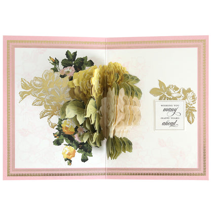 An open pop-up greeting card made with the Folded Rose Card Making Kit, featuring layered yellow and cream flowers, 3D embellishments, and a printed message: "Wishing you many happy years ahead.