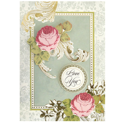 Greeting card featuring ornate gold designs, two pink roses with green leaves, and "Love You" in cursive—ideal for pairing with the Folded Rose Card Making Kit.
