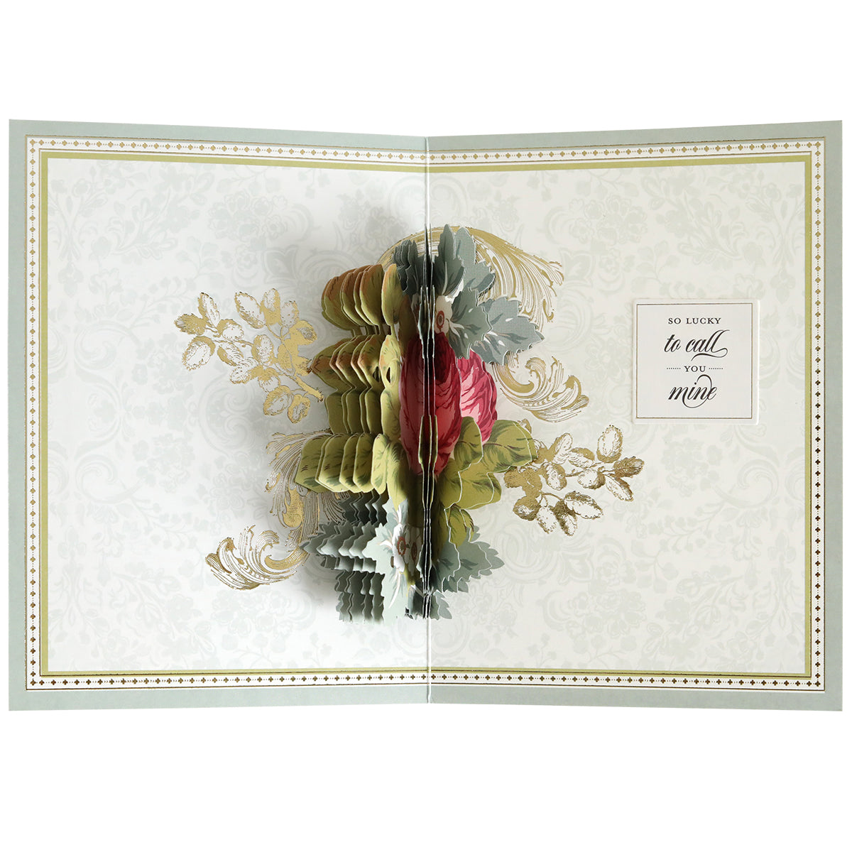 An open greeting card created with the Folded Rose Card Making Kit displays a 3D pop-up floral arrangement and a heartfelt message on the right: "So lucky to call you mine.