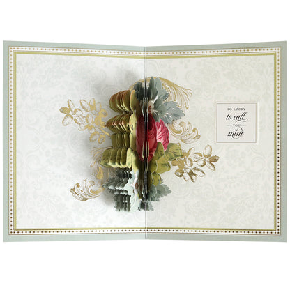 An open greeting card created with the Folded Rose Card Making Kit displays a 3D pop-up floral arrangement and a heartfelt message on the right: "So lucky to call you mine.