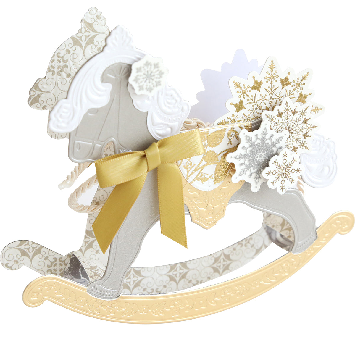 A decorative paper rocking horse created with Rocking Horse 3D Dies, featuring a gold bow and intricate white and gold snowflakes—ideal for holiday crafts or celebrating baby milestones.
