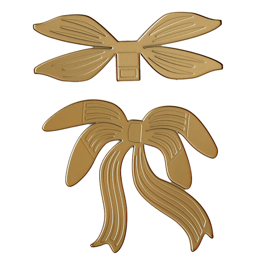 Two gold bows, made with the Flowing Bow Die, feature engraved lines—one has straight ribbon ends and the other flowing curves—making them perfect accents for card making or paper projects on a white background.