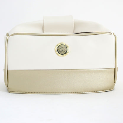 A two-tone handbag with cream and beige panels, gold medallion detail on the front, styled next to an Empress Mini Elite Dust Cover, displayed against a plain white background.