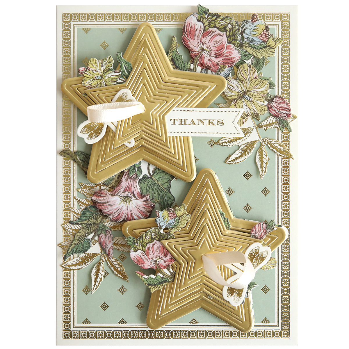 A decorative card featuring two-dimensional stars created with Kirigami Star Dies, floral accents, and a "THANKS" banner on a patterned pale green background.