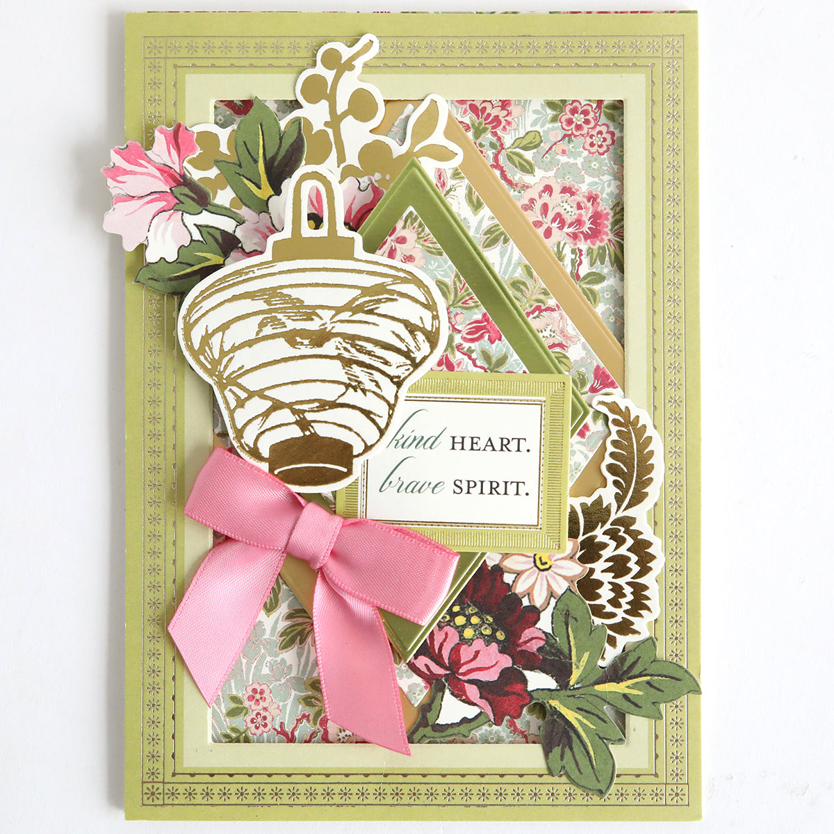 The Card Layer Photo Mat Bundle includes a handmade greeting card with floral patterns, a gold lantern, and "kind heart. brave spirit." message—ideal for cardmaking or scrapbooking projects.