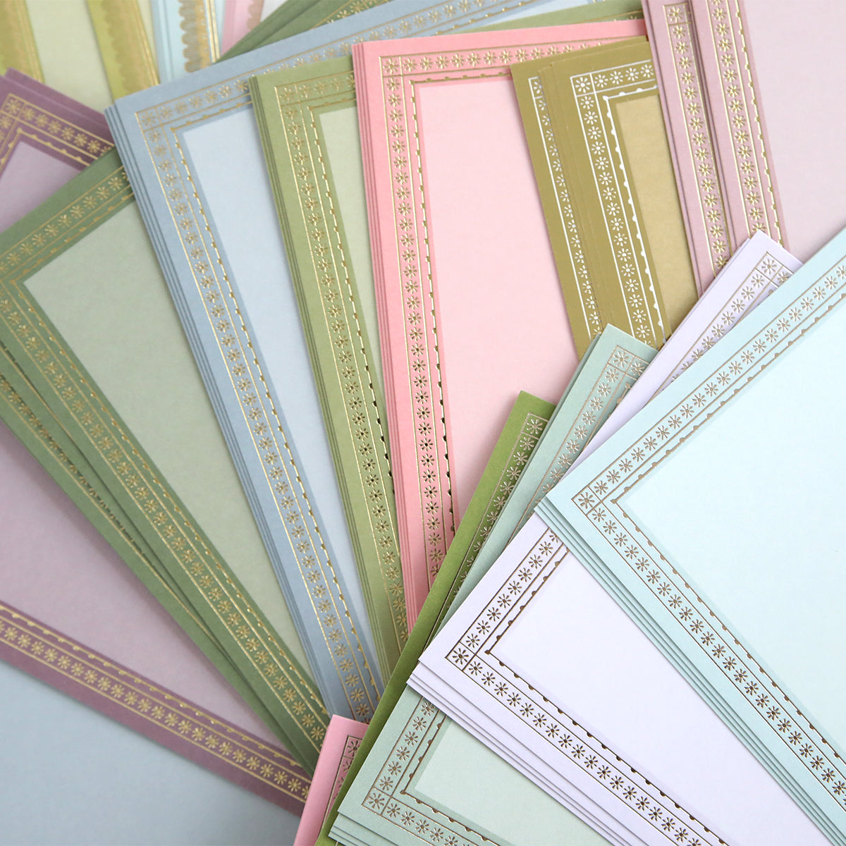 The Card Layer Photo Mat Bundle features pastel certificate papers with decorative gold borders, overlapping elegantly—ideal for cardmaking or as photo mats in your next scrapbooking project.