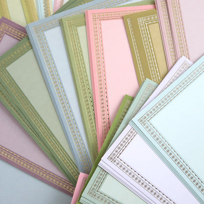 The Card Layer Photo Mat Bundle features pastel certificate papers with decorative gold borders, overlapping elegantly—ideal for cardmaking or as photo mats in your next scrapbooking project.